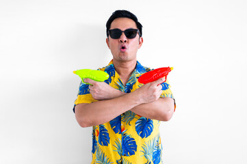 Thai male get excited while holding blurred focus of water guns wearing colorful shirt for Thailand Songkran festival concept.