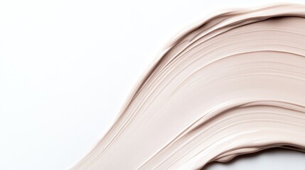 abstract smooth spread of cream foundation with soft beige tones contrasted against plain white backdrop
