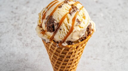 A delicious ice cream scoop topped with caramel, served in a crispy waffle cone against a light background.