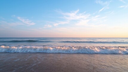 Fototapeta premium A serene beach scene at sunset, featuring gentle waves and a vibrant sky, creating a tranquil atmosphere perfect for relaxation.