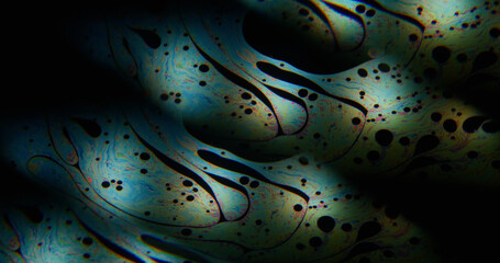 Art flow. Multicolor paint. Spectrum petrol droplet stream clone spill abstract pattern on black liquid background. Defocused duplicated gradient mix.