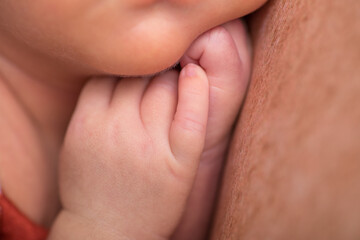 Newborn baby human little fingers and hands being held close up