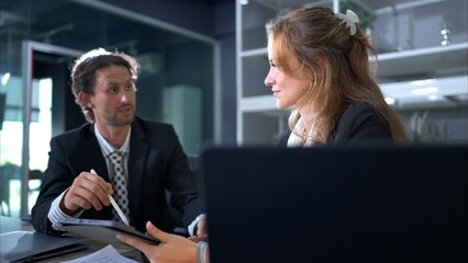 In the office, two businessmen and women discuss and exchange idea and give advice to each other to complete the work