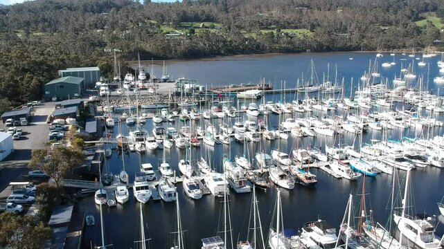 Aerial drone footage of Oyster Cove Marina and Little Kettering Marina, Bruny Island, Tasmania, showcasing boats, calm waters, scenic coastline, lush surroundings, and a tranquil harbor