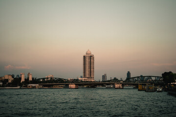 Fototapeta premium A scenic view of the Phra Phutthayotfa Bridge spanning the Chao Phraya River in Bangkok, captured from the River Walk near Wat Kanlayanamit Woramahawihan. The bridge.