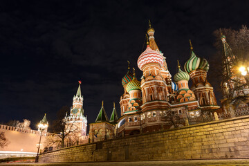 Fototapeta premium Moscow, Russia. Evening view of St. Basil's Cathedral and the Spasskaya Tower of the Moscow Kremlin. Sights of Moscow. Dark night sky.