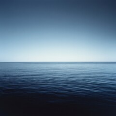 Obraz premium Serene Horizon Over Calm Ocean Waters at Twilight with Gentle Waves Reflecting Soft Blue Sky and Sea in a Peaceful Natural Setting