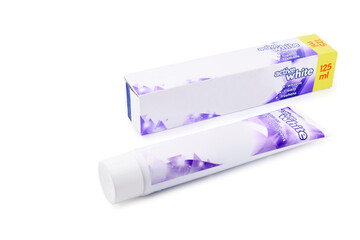 fresh fluoride toothpaste in tube and cardboard packaging, close-up on white background