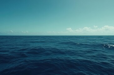 Obraz premium Tranquil Blue Sea Under a Clear Sky with Gentle Waves and Soft Clouds in the Distance Conveying Serenity and Peacefulness of Open Water