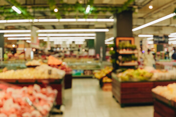 Blurry image of a grocery store with a lot of fruit and vegetables.