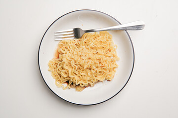 Indonesian fried noodles named Indomie, topped with fried onions, served on a white plate.