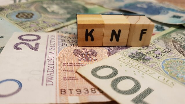Polish PLN banknotes and KNF inscription made of letter cubes. Financial Supervision Authority