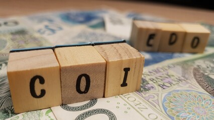 Polish PLN banknotes and COI and EDO inscription made of letter cubes. Savings bonds indexed to inflation