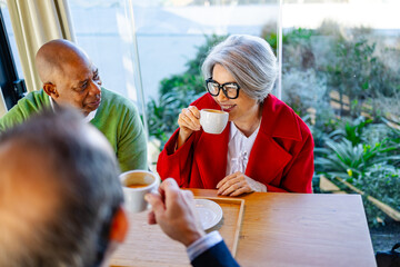 Group of friends sharing coffee and chatting at a cozy cafe