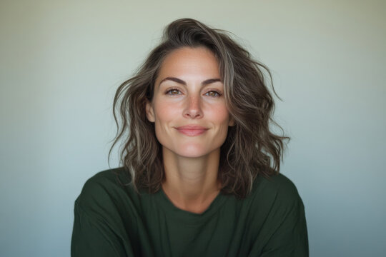 Portrait of smiling mid adult woman with brown hair and green shirt