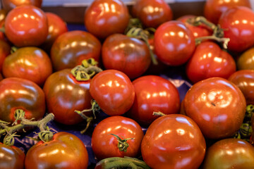 Vibrant heirloom tomatoes with a glossy texture and deep colors displayed at a farmers market. Ideal for food photography, organic produce, healthy eating, and farm-fresh visuals