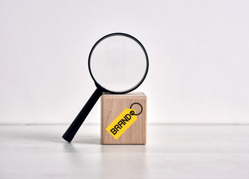 Magnifying glass inspecting brand reputation on wooden cube