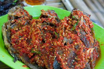 Spicy Indonesian-style tilapia dish, captured on March 4, 2025. Fresh tilapia cooked with rich spices and chili, creating a bold and flavorful traditional dish