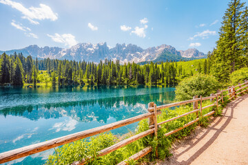 Karersee mountain lake in the Dolomites landscape, South Tyrol alps, Italy, also known lake Carezza. Reflection green on lake.