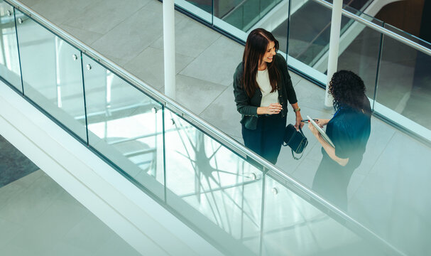 Coworkers chatting in a modern office environment