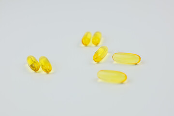 Yellow omega 3 fish oil capsules lie on a white background. The concept of vitamins, dietary...