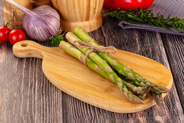 Raw green asparagus over board