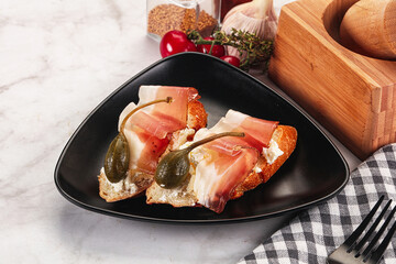 Bruschetta with jamon and caper berries