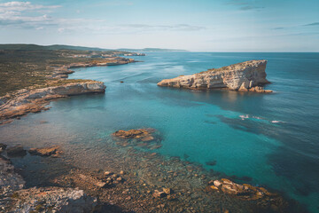 Obraz premium Scenic coastal view featuring rocky cliffs and clear blue water in a tranquil setting