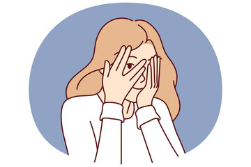 Woman covers eyes with hands and peeps, refusing to see unpleasant things and hiding from problems. Cute girl coquettishly covers face and peeps at your actions through crack in fingers