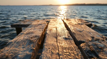 Fototapeta premium The wooden pier is in the water and the sun is setting