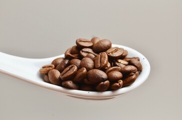 roasted coffee beans close up on spoon