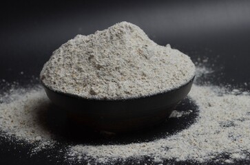 whole wheat flour in a bowl on a black background