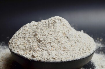 whole wheat flour in a bowl on a black background