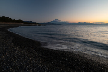 朝焼けの富士山を海岸から眺める