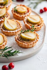 Beautifully detailed photograph of festive mini tartlets with golden brown flaky crust, filled with creamy duck pate and topped with delicate pickled pear slices, presented on a clean white plate
