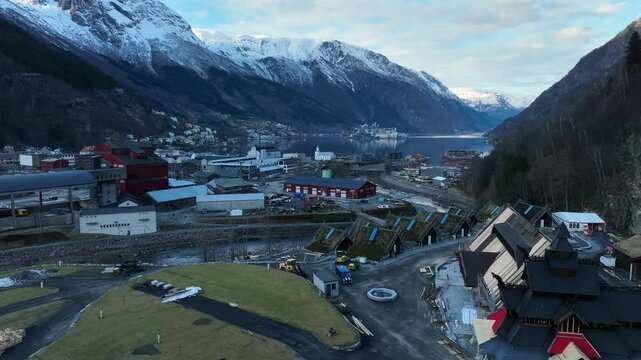 Aerial over Lothepus Camping in Odda Norway. Main building, stave church, and cabins with fjord view.