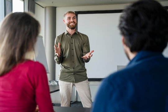 Young man giving a presentation to colleagues in a German office