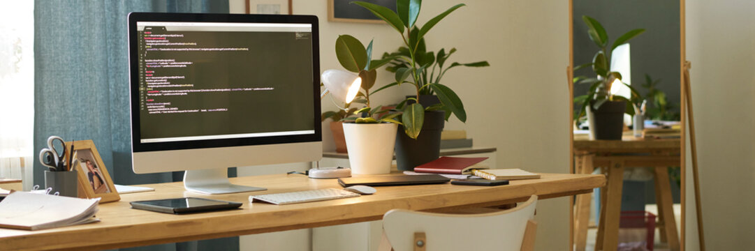 Home office workspace with computer and coding on screen