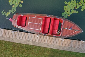 Aerial view of a classic wooden boat docked by a pier.