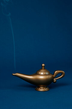 Magic lamp with smoke on a blue background in a studio setting