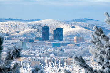 Brno, Czech Republic - View of the winter snowy city center. Tall skyscrapers with mountains in the background.