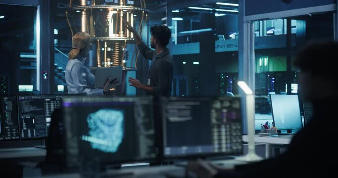 Two Diverse Male and Female Engineers Monitoring Performance of a Quantum Processor. Asian Data Scientist Optimizing Artificial Intelligence Algorithm, Manipulating Qubits on a Desktop Computer