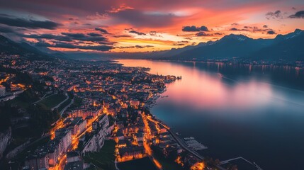 Drone view of Montreuxs evening lights reflecting on Lake Geneva, with vineyards bathed in the soft glow of sunset.