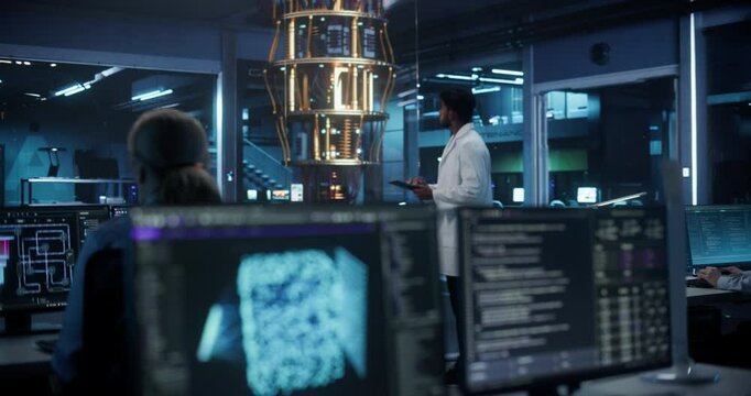 Young Indian Scientist Inspecting a Quantum Computer, Using a Tablet to Implement Complex Software Systems. Foreground with Artificial Intelligence Models on Office Screens