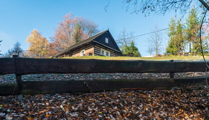 Isolated wooden house with colorful trees on the background in Slezske Beskydy mountains in Czech...
