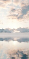 Misty morning in a tranquil landscape with mountains and lake
