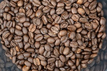 Close-up of roasted arabica coffee beans.Heap of coffee beans stacked  prepare making menu in the cafe by machine ready to be brewed into a delicious cup.Textured background.