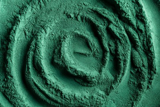 Heap of green spirulina algae powder, closeup, top view. Green powder super food, macro. Dietary supplement to improve health. Seaweed superfood concept. Healthy food background