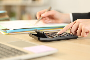 Woman at business accounting using calculator at office