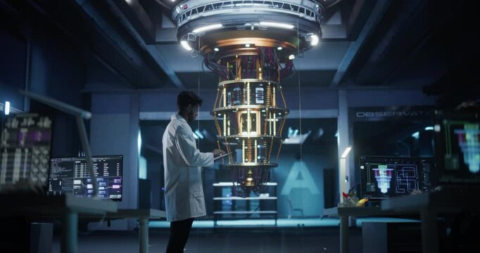 Indian Scientist Using a Tablet to Monitor the Work of a Quantum Computer, Focusing on Data Flow, Compute and Hardware Stability. Futuristic Dark Setting with Advanced Technological Office